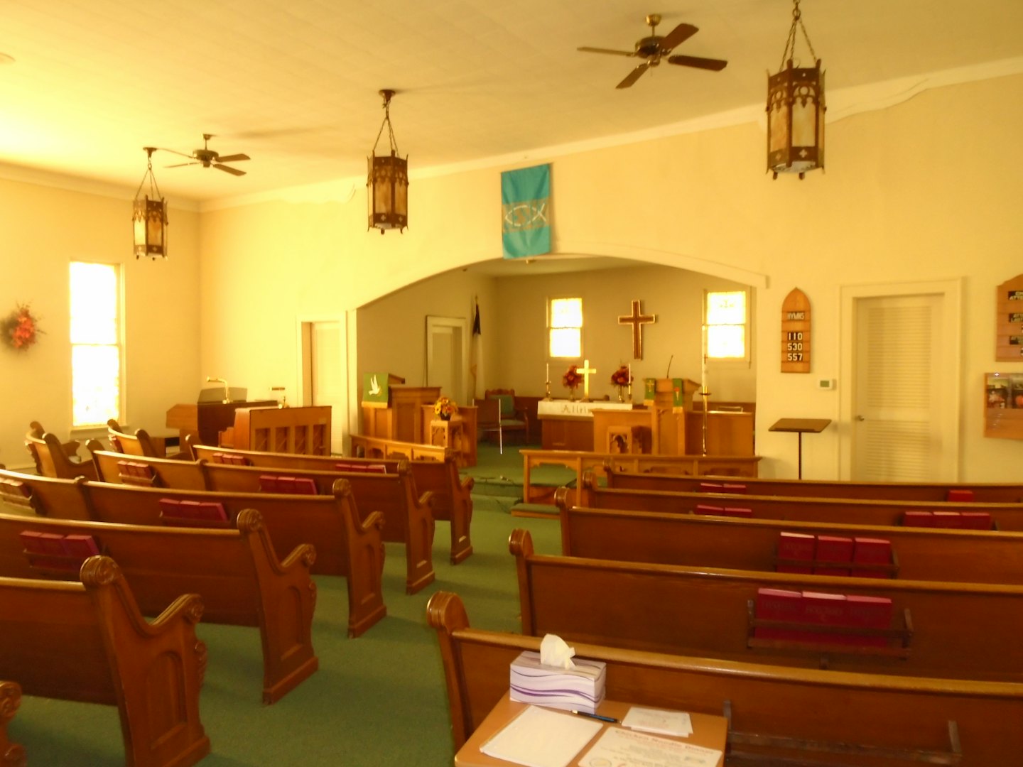 Empty church sanctuary with wooden pews facing an altar.