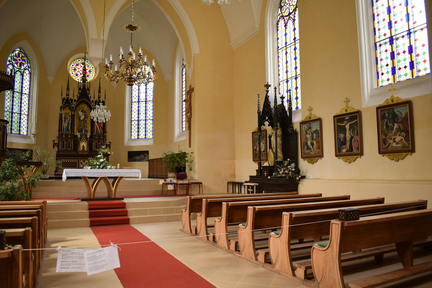 Wooden pews face the decorated altar in a sunlit church sanctuary.